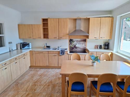 a kitchen with wooden cabinets and a table with chairs at Apartment 1 in Diepholz