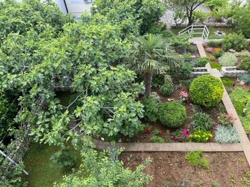 a garden with plants and flowers and a bench at Apartman Laura in Dramalj