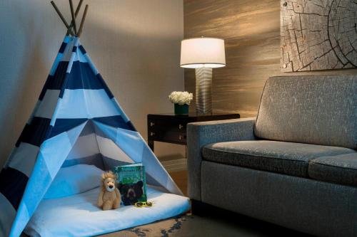 a toy dog sitting on a bed next to a couch at The Ritz-Carlton, Denver in Denver