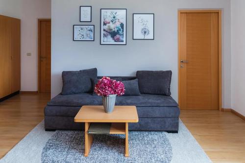 a living room with a couch and a table with flowers at Florianshof in Tesimo