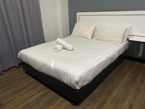 Una cama con un teléfono sentado encima. en Swing & Pillows - NueVo Boutique Hotel Kota Kemuning en Shah Alam