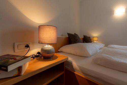 a bedroom with a bed and a table with a lamp at Florianshof in Tesimo