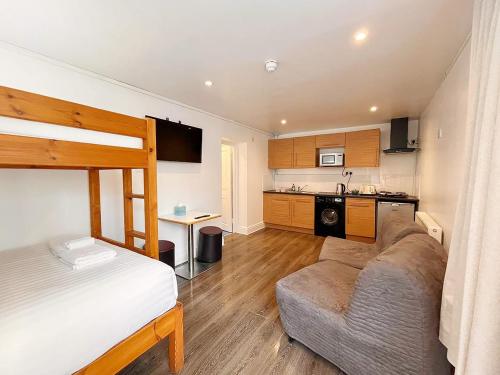 a bedroom with a bed and a couch and a kitchen at Reef Lodge in Newquay