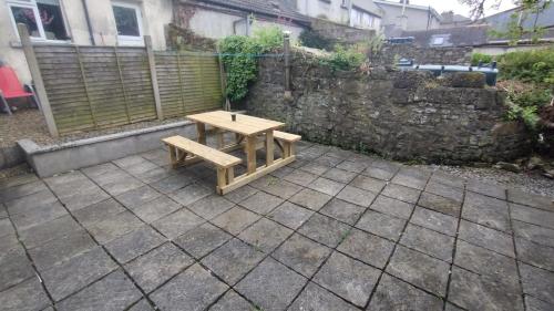 una mesa de picnic de madera en un patio en Small Town House, Barrow Lane, Bagenalstown, Carlow, en Bagenalstown