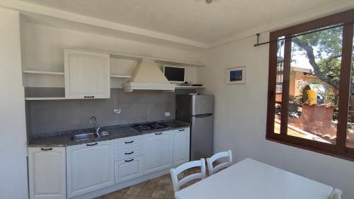 a kitchen with white cabinets and a table and a window at Appartamenti Pagni in Casa Morcone