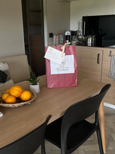 a bag sitting on a table with a bowl of oranges at Glamping Tuscany - Podere Cortesi in Santa Luce