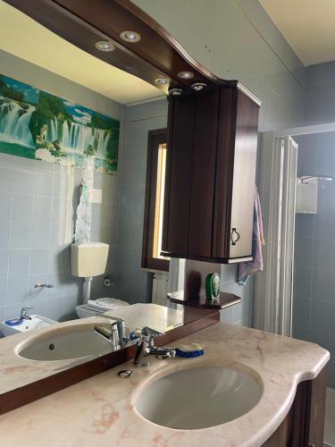 a bathroom with a sink and a mirror at Silvia Miotto's Guesthouse in Guia