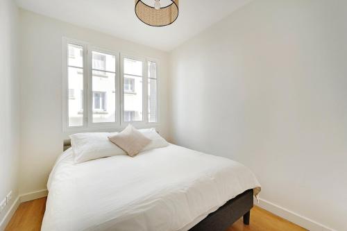 une chambre avec un lit blanc avec une fenêtre dans l'établissement T3 Boulogne - Roland Garros/Parc des Princes, à Boulogne-Billancourt