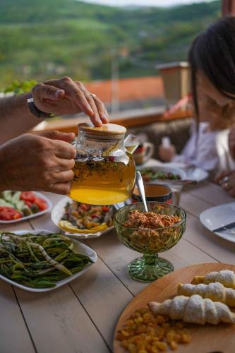 a group of people sitting at a table with food at Chamich Guesthouse in Debed