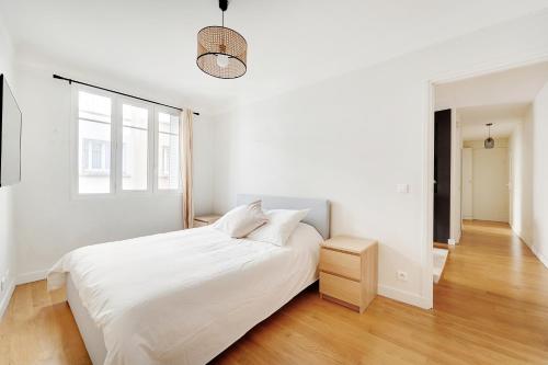 une chambre blanche avec un lit et une fenêtre dans l'établissement T3 Boulogne - Roland Garros/Parc des Princes, à Boulogne-Billancourt