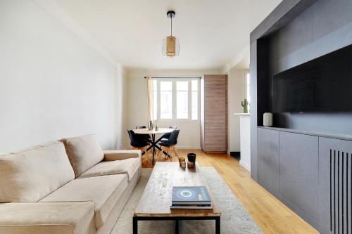 un salon avec un canapé et une table dans l'établissement T3 Boulogne - Roland Garros/Parc des Princes, à Boulogne-Billancourt