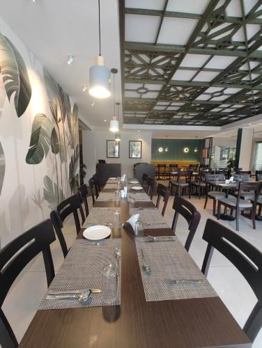 a long table in a restaurant with tables and chairs at Abad Fort in Cochin