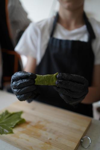 a person in black gloves holding a piece of food at Chamich Guesthouse in Debed