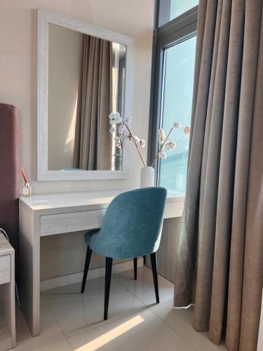 einen Schreibtisch mit einem Spiegel und einem Stuhl in einem Zimmer in der Unterkunft Serenity Suites studio in Seven Palm corner view in Dubai