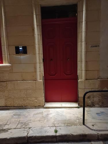 a red door on the side of a building at Number 12 in Birgu