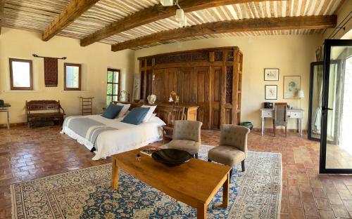 une chambre avec un lit, une table et des chaises dans l'établissement Villa Helios, à Rustrel