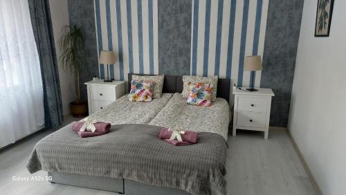 a bedroom with a bed with pillows and two night stands at Apartament 42C in Ciechocinek