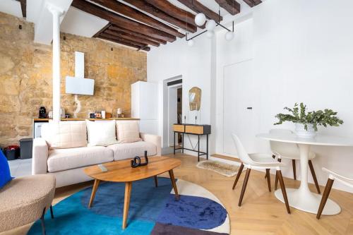 un salon avec un canapé blanc et une table dans l'établissement Typical Parisian Apart#Quatier Latin#Notre Dame#, à Paris