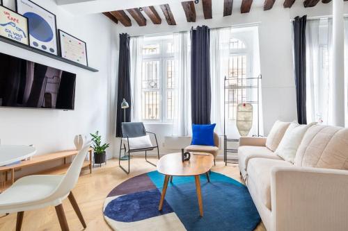 - un salon avec un canapé blanc et un tapis bleu dans l'établissement Typical Parisian Apart#Quatier Latin#Notre Dame#, à Paris