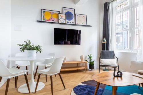 un salon avec une table et des chaises blanches dans l'établissement Typical Parisian Apart#Quatier Latin#Notre Dame#, à Paris