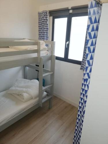 une chambre avec deux lits superposés et une fenêtre dans l'établissement Chai restauré au cœur du village, à Ars-en-Ré