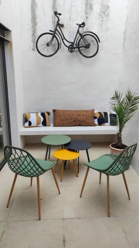 une table avec quatre chaises et un vélo sur un mur dans l'établissement Chai restauré au cœur du village, à Ars-en-Ré