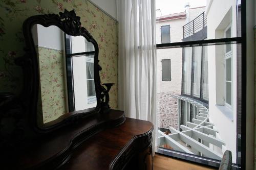 a mirror sitting on a dresser next to a window at Antonius Hotel in Tartu