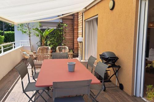 une table et des chaises rouges sur une terrasse avec balcon dans l'établissement Sumptuous renovated apartment in Antibes, à Antibes