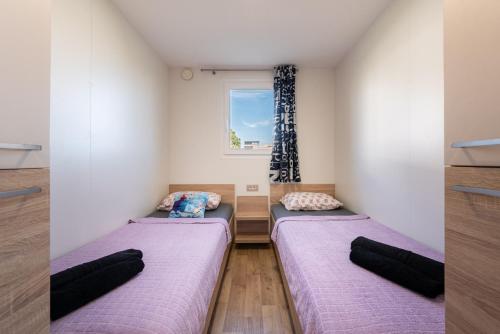 2 Betten in einem Zimmer mit Fenster in der Unterkunft Mobile house Seashell in Pakoštane