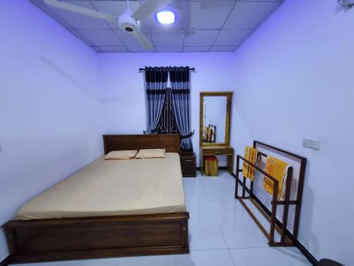 a bedroom with a bed and a mirror in it at Nilaveli Guest House in Nilaveli