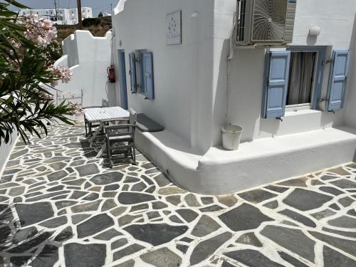 a patio with a bench and a table on a stone floor at Villa Margarita in Mýkonos City
