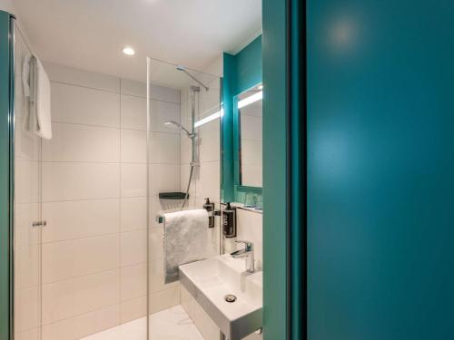a bathroom with a sink and a glass shower at ibis budget Berlin Kurfürstendamm in Berlin