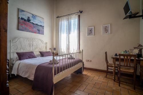 Schlafzimmer mit einem Bett, einem Fenster und einem Schreibtisch in der Unterkunft Il Castellaro in Borghi