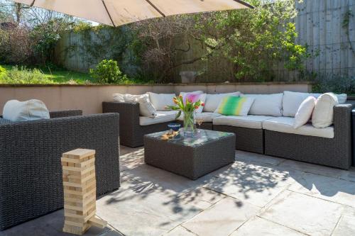 a patio with a couch and chairs and an umbrella at The Brackens in Seaview