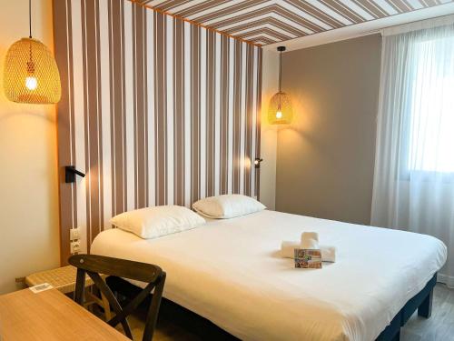 Un dormitorio con una cama con una caja. en ibis Styles Nimes Gare Centre, en Nimes