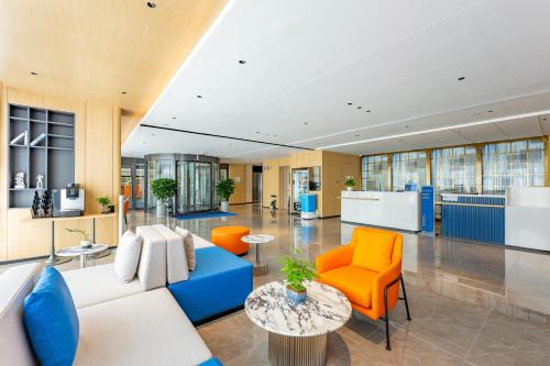 an office lobby with orange and blue chairs at Holiday Inn Express Langfang Yanjiao by IHG in Langfang