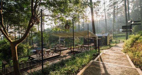 a picnic shelter with tables in a forest at Bobocabin Pacet, Mojokerto in Claket