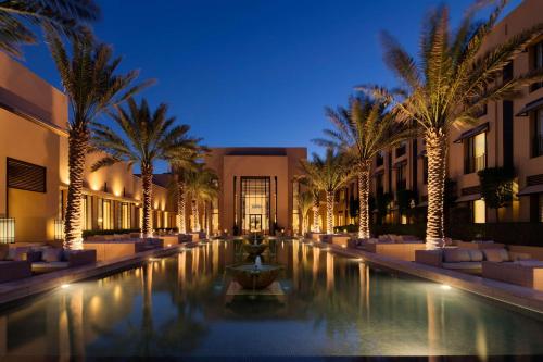a resort with a pool and palm trees at night at Park Hyatt Jeddah - Marina, Club and Spa in Jeddah