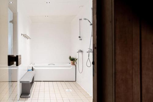 a white bathroom with a tub and a shower at Pihla Inspiratsioonitalu peamaja in Kõpu