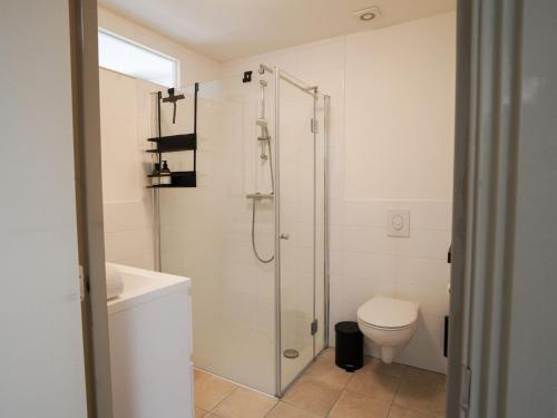 La salle de bains blanche est pourvue d'une douche et de toilettes. dans l'établissement Long John's Pub & Hotel, à Amersfoort