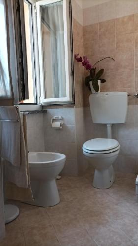 a bathroom with a toilet and a sink and a window at Quick Home - Interno 45 in Biella