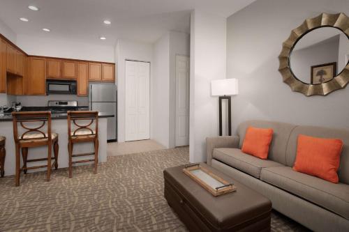 a living room with a couch and a table and a kitchen at Embassy Suites La Quinta Hotel & Spa in La Quinta