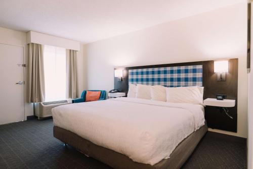 um quarto de hotel com uma cama grande com lençóis brancos em Hampton Inn Gatlinburg em Gatlinburg