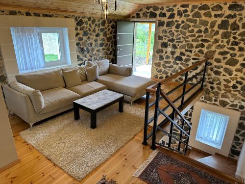 a living room with a couch and a stone wall at 3 VELLEZERIT DOCI GUEST HOUSE in Fushë-Lurë