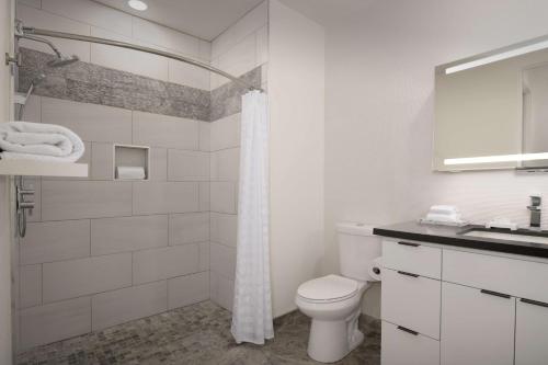 a white bathroom with a toilet and a sink at Embassy Suites La Quinta Hotel & Spa in La Quinta