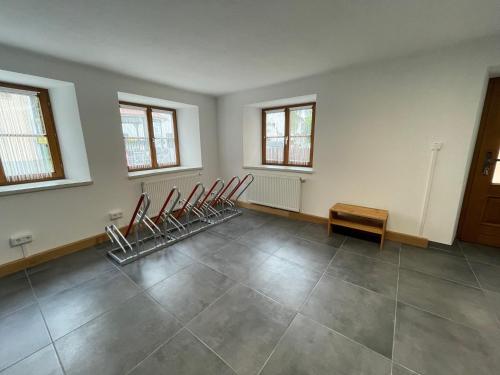 an empty room with four chairs and a table at Thorbäck Gut - Apartments im Schlosserhaus in Öblarn