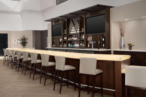 a bar with white chairs and a long counter at Embassy Suites La Quinta Hotel & Spa in La Quinta