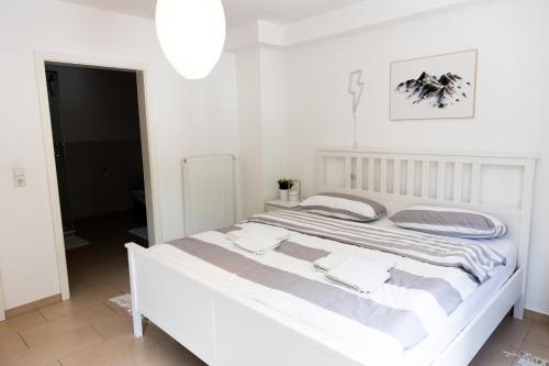 a white bedroom with a large white bed at Designer Loft City Center, Secured parking, cozy Apartment, Adenau Nürburgring in Adenau
