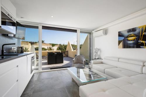 un salon avec un canapé blanc et une table en verre dans l'établissement Sexy Dream Heliopolis, au Cap d'Agde