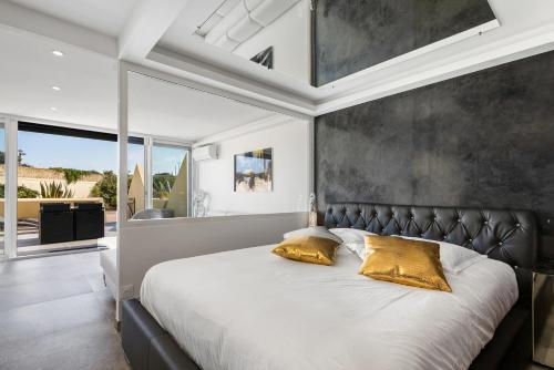 une chambre avec un grand lit avec une tête de lit noire dans l'établissement Sexy Dream Heliopolis, au Cap d'Agde